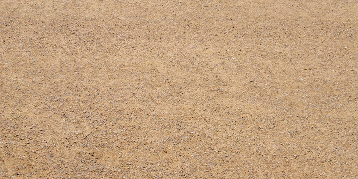 Fine beige gravel sand ground surface texture background with small pebbles