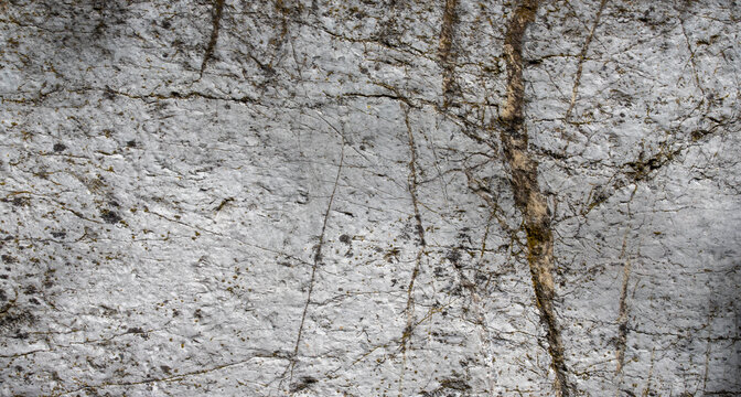 Rough light grey stone surface texture background with natural dark veins