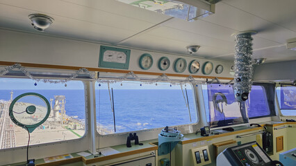 Inside view of marine vessel navigation bridge control room with gauges radar screens and simple christmas decorations tinsel for away from home workplace psychology © moryachka