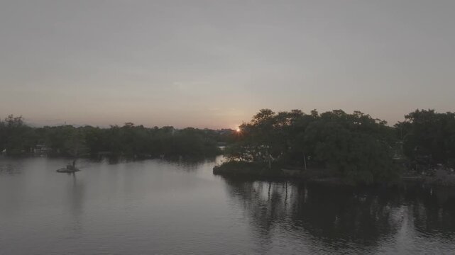 Sunset over Con Hen Islet in the Perfume River, Vy Da Ward, Hue City, Vietnam, showcasing the tranquil river landscape and the scenic beauty of Hue at dusk.