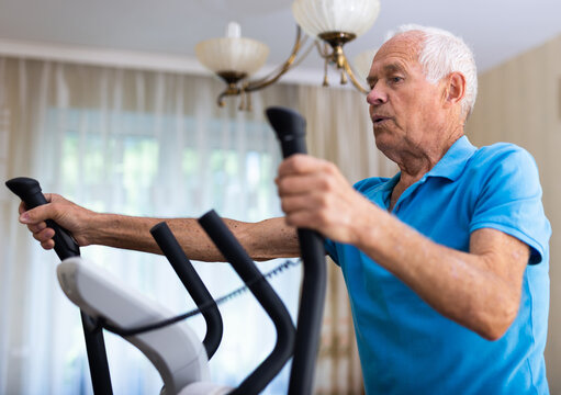 Male is working out on elliptical machine for elder healthy concept