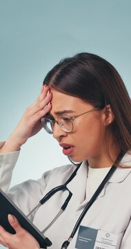 Doctor, woman and stress in studio with tablet, medical research and bad news for patient diagnosis. Healthcare worker, person and concern with tech, online test results and error on blue background.