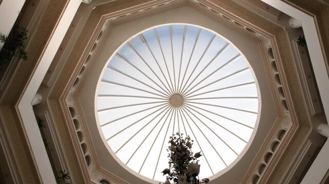Looking up at the skylight glass roof of an atrium, with geometric structure in modern contemporary architectural style