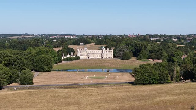 People playing cricket in front of the historic copped hall mansion