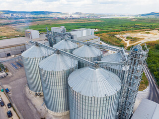 Industrial grain storage facility located in a rural area with large silos during daytime © DSMT