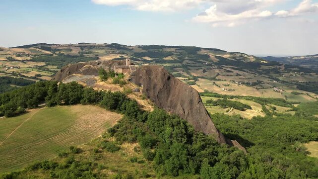 Europe, Italy, Travo , Drone aerial view Pietra Perduca is a  volcanic rock with the  church set in stone immersed in a  countryside landscape with cultivated land in Val Trebbia Bobbio Emilia Romagna