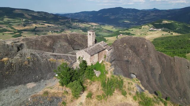 Europe, Italy, Travo , Drone aerial view Pietra Perduca is a  volcanic rock with the  church set in stone immersed in a  countryside landscape with cultivated land in Val Trebbia Bobbio Emilia Romagna