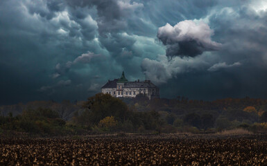 Fototapeta premium Historic Olesko Castle on a hill under dramatic stormy sky with dark clouds