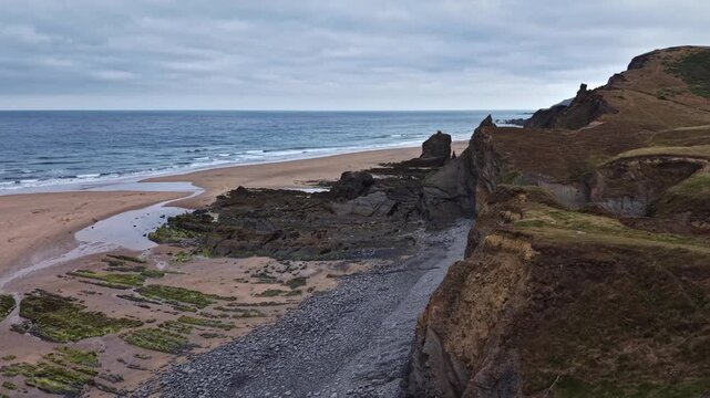 Morning view of the cliffs and beach at sandymouth Bay Cornwall