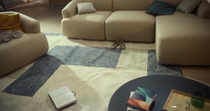 Creative Swirling Camera Glides From an Open Book on the Living Room Rug to a Woman Browsing Talking on Phone in the Background. Home Reading, Casual Study, Leisure and Digital Distraction.