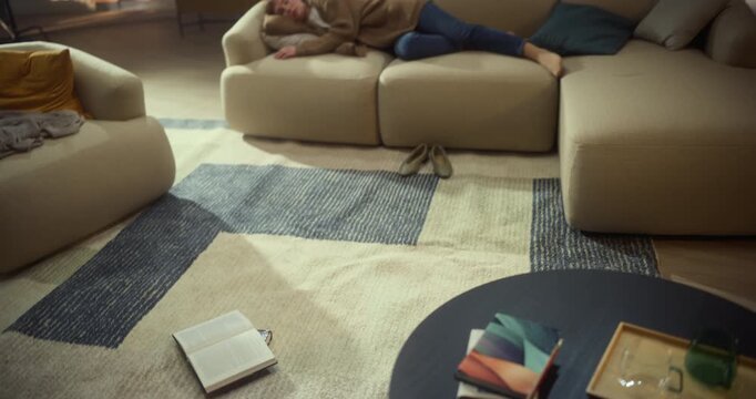 Swirling Overhead Shot Circles an Open Book on Rug, Then Reveals a Woman Resting on a Couch. Tired Student Resting after Intense Study for Exams, Reading Break, Home Study Pause, Mindful Leisure