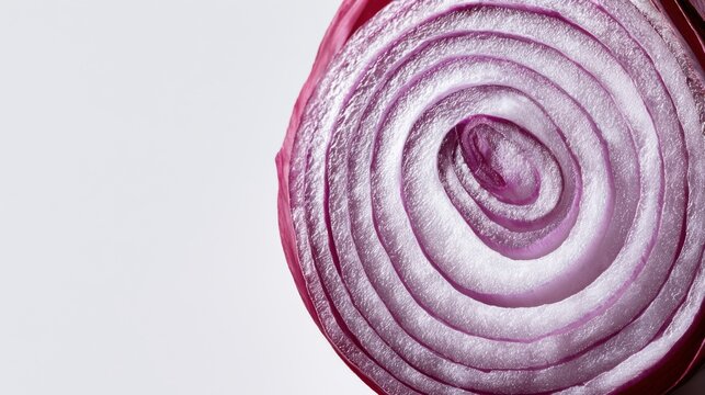 Close-up of a sliced red onion revealing its concentric rings and vibrant purple color, on a light background