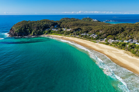 Aerial view of Sugarloaf Point surrounded by crystal-clear turquoise waters and the rugged coastline at Seal Rocks, NSW, Australia, highlighting the natural beauty of this iconic coastal headland.