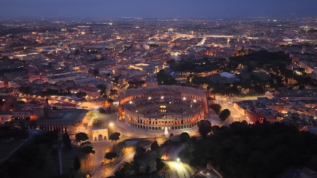 Rome, Italy. Aerial night 4K panoramic drone view of the city at dusk. Majestic view of the ancient city skyline with Basilics, Coliseum, ancient ruins, iconic buildings. Europe from above.