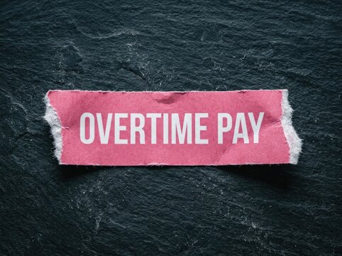 Overtime Pay, a torn pink paper strip with bold white lettering, signifying extra work and financial compensation on a dark textured background.