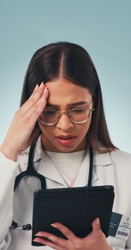 Doctor, woman and bad news in studio with tablet, medical research and stress for patient diagnosis. Healthcare worker, person and concern with tech, online test results and error on blue background.