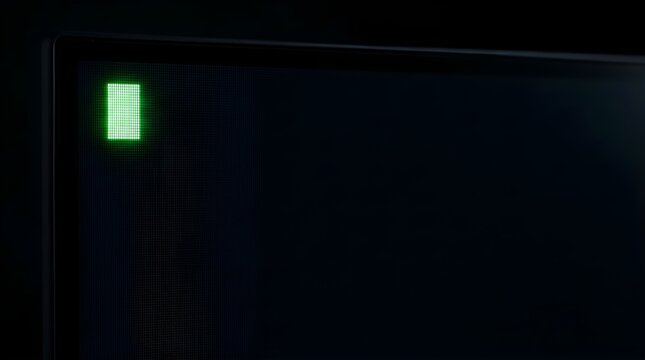Glowing green pixel cursor on a dark computer monitor screen at night