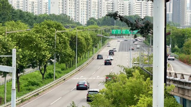 Urban Freeway Traffic Overpass View with Greenery and City Skyline
