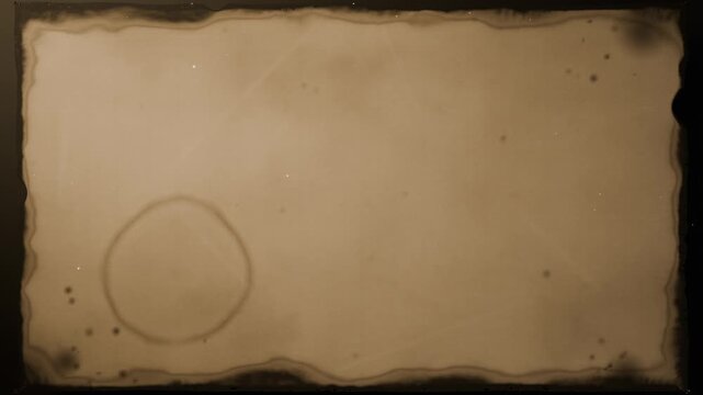 Unrolling scroll revealing aged parchment at studio backdrop, showing ring stain, then re-rolling