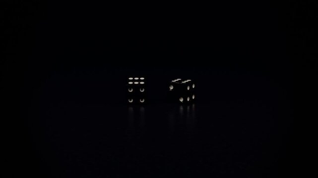 Falling two dice colliding from upper-right, settling on black table, resting, revealing amber pips