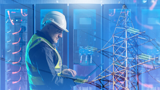 Energy storage industry. Power engineer monitors battery energy storage systems and electrical infrastructure using laptop in data center.
