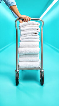 Laundry cart with folded white towels on vibrant blue background