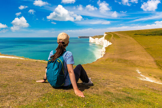 Female hiker on coastal trail at Seven Sisters white chalk cliffs, East Sussex, England, UK
