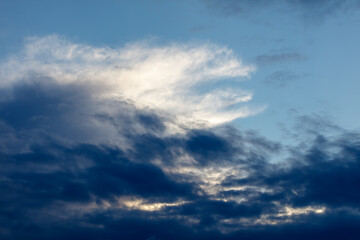 Fototapeta premium Dramatic sky with dark clouds and bright illuminated wisps