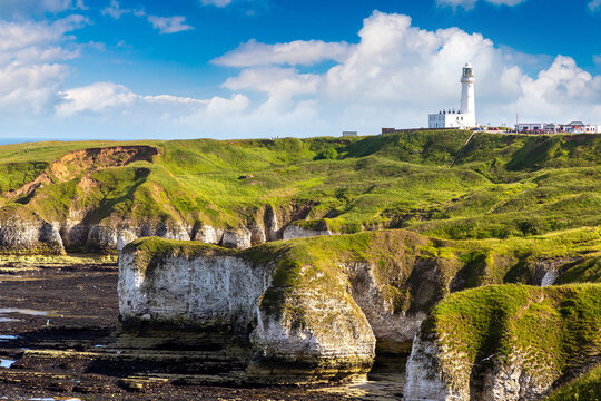 White chalk cliffs of Selwicks Bay with Flamborough Head lighthouse, England, UK