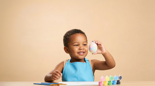 African child painting easter egg with bright colors and brushes