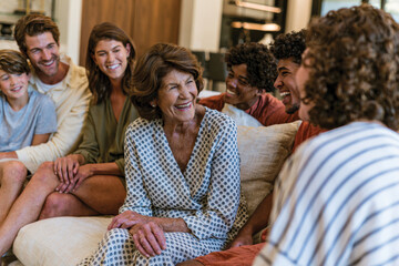 Fototapeta premium An endearing moment of a grandmother laughing with her family, reflecting happiness, connection, and the beauty of shared joyful experiences in a homely setting.