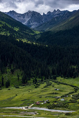 Alpine valley landscape on Genie South Line Sichuan China, winding river, grassland village and dense coniferous forest on western Sichuan plateau © Deng Xuejun