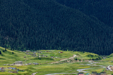 Alpine valley landscape on Genie South Line Sichuan China, winding river, grassland village and dense coniferous forest on western Sichuan plateau © Deng Xuejun