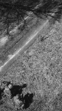 Aerial view of American WWII soldiers walking along dirt road