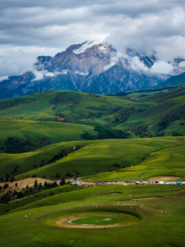 defaAerial view of Genie Eye natural circular meadow, Genie South Line Sichuan China, rolling alpine grassland and snow mountain shrouded in clouds, western Sichuan plateau landscapeult