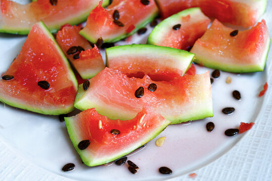 Dirty plate with watermelon peel and seeds on a plate. Fresh summer fruit. Healthy deit food.