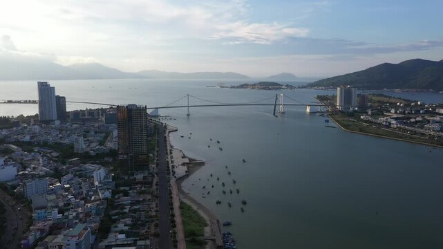 Aerial drone footage of Da Nang city skyline and the iconic bridges spanning the Han River, Vietnam. The clip features panoramic views of Dragon Bridge (Cau Rong), Tran Thi Ly Bridge, Thuan Phuoc 