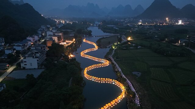 Chinese dragon in the night,Aerial view of fireworks over the river and town at night, Baisha Town, Yangshuo, China