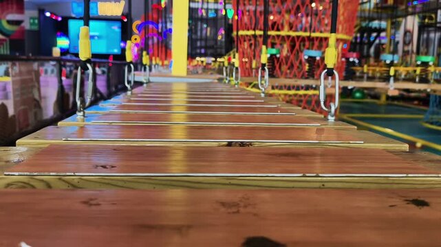 Wooden plank suspension bridge obstacle course in an indoor adventure park
