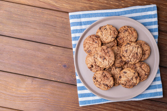 Chocolate chip cookies on a plate over wooden table with copy space