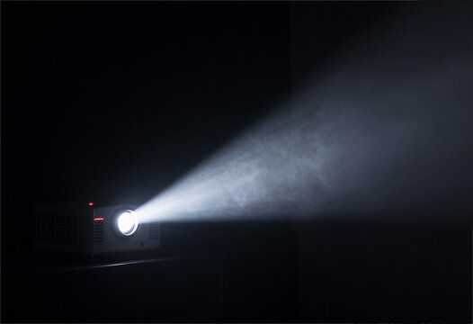 Projector light beam in dark room, smoke