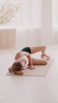 Woman in yoga outfit doing clamshell exercise on rig at home