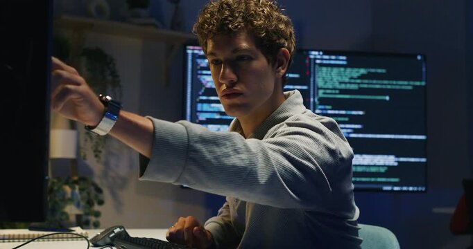 Hispanic man developer works overtime tracing bugs running tests deploying patches and coordinating with IT support to maintain reliable application services.