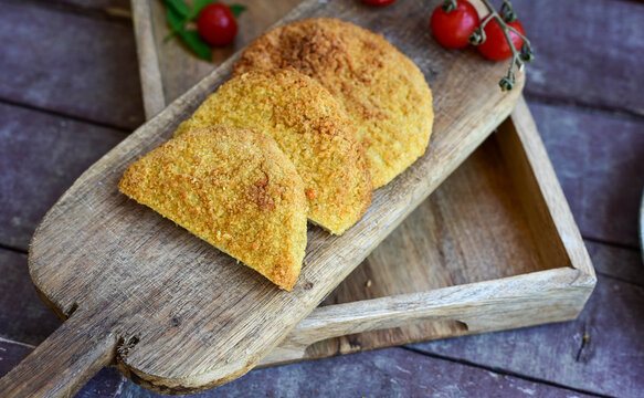 Crispy  deep fried   chicken  burgers . Breaded  with cornflakes chicken  breast fillets  with  french fires and fresh    aragula on wooden rustic background
