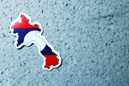 Laos Map with National Flag Symbol on Blue Textured Background with Copy Space