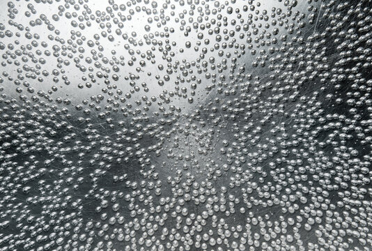 Bubbles of boiling water in cooking pot, top view