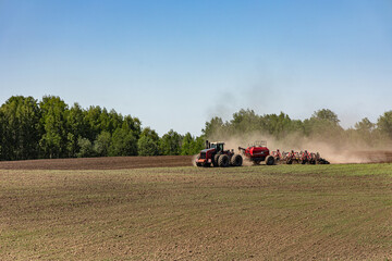 Obraz premium Modern tractor seeding agricultural field during spring planting season