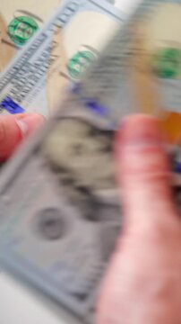 Male hands counting US Dollar bills, close-up