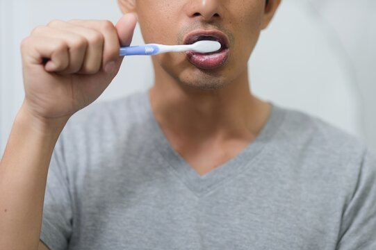 Close-Up of Man Brushing Teeth with Toothbrush and Toothpaste