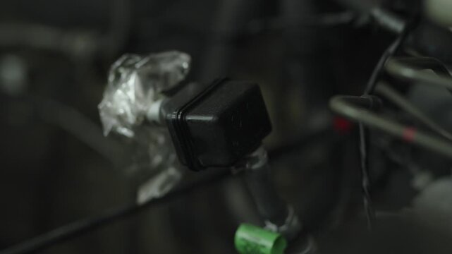 Black plastic fuel check valve with tubes in engine bay.